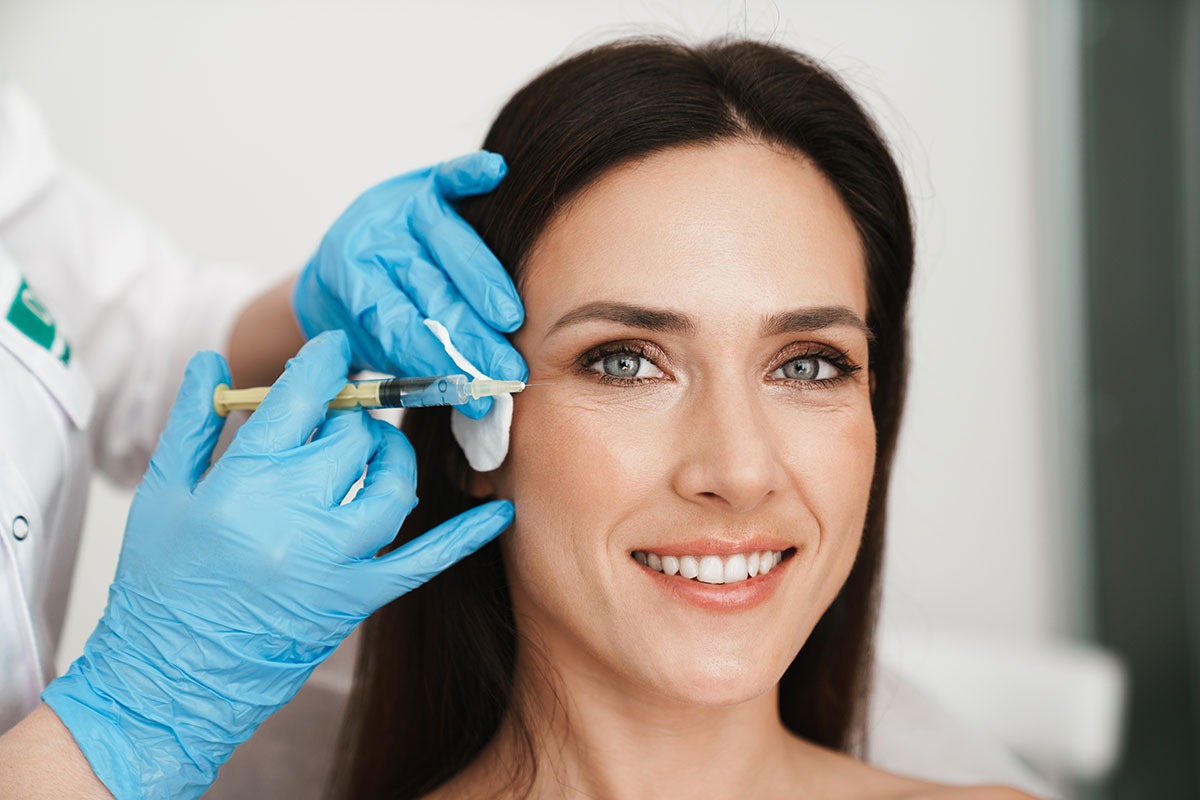 Photo of smiling woman getting mesotherapy treatment in face